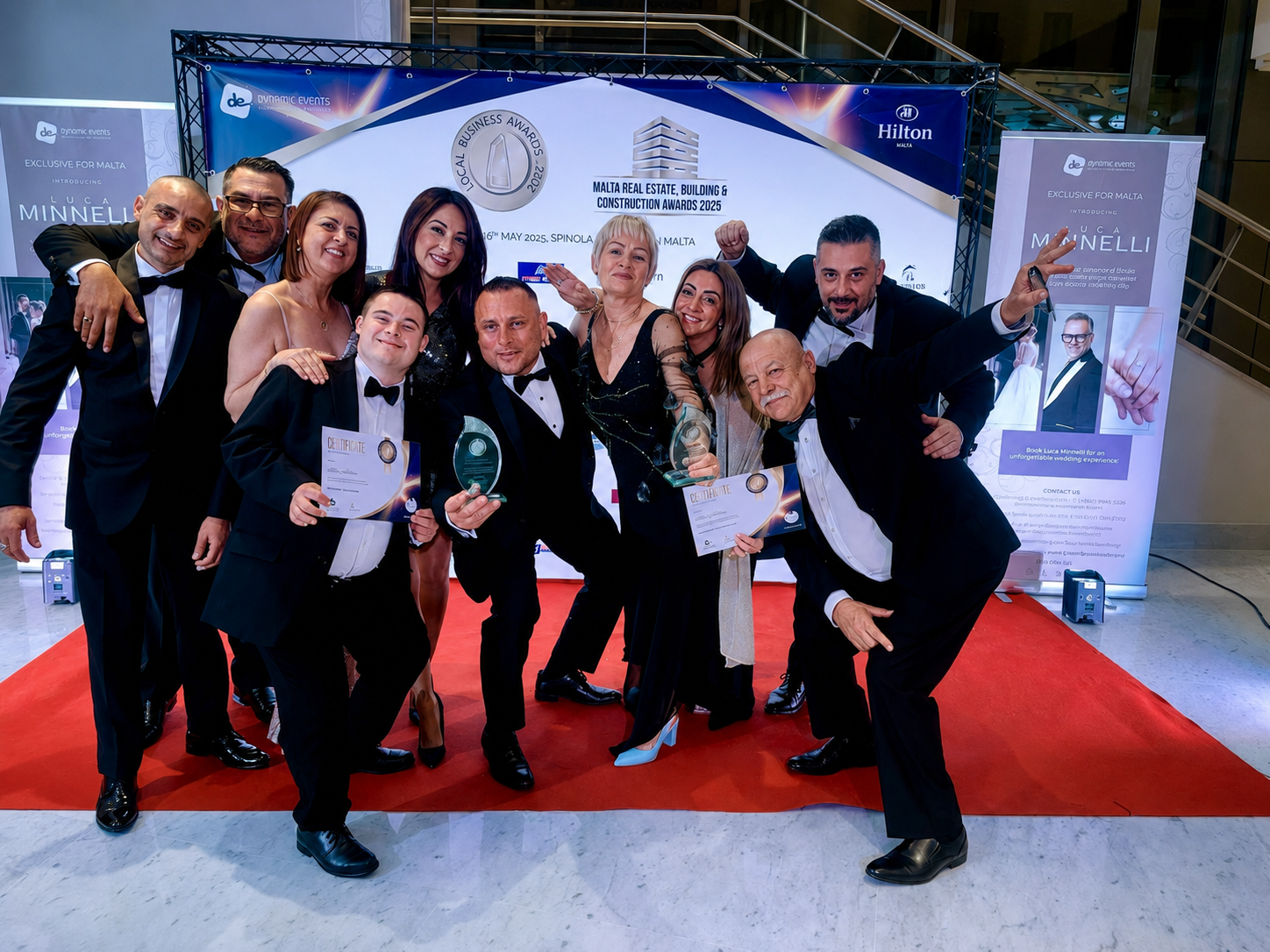 The Alan Motors team celebrating with their trophies and certificates at a Malta business awards ceremony